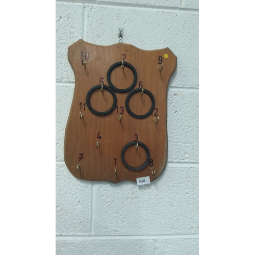 430 - Vintage wooden ring toss game board with numbered hooks and rubber rings.