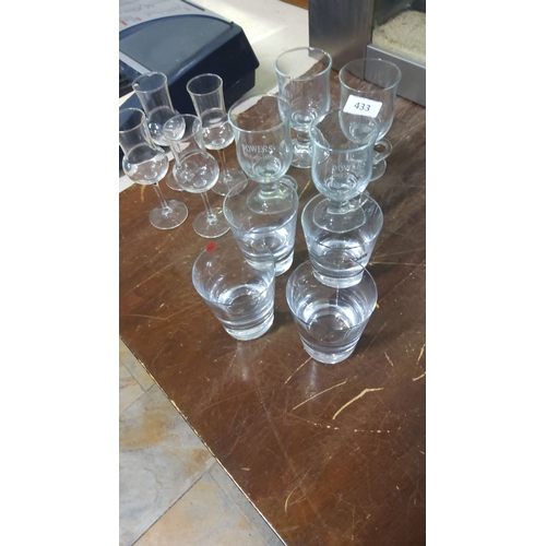 433 - Set of branded assorted drinking glasses, including branded Powers Gold Label glasses.