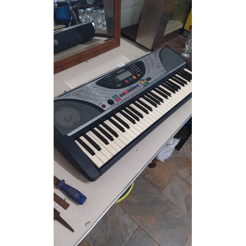 439 - Yamaha electronic keyboard with various function buttons and digital display. Includes built-in spea... 