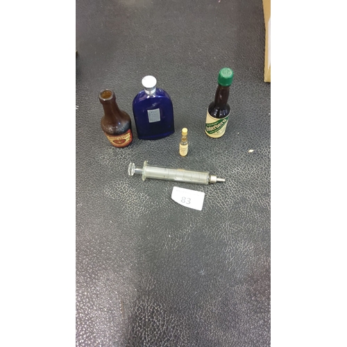 83 - Mixed lot includes blue and amber glass bottles and a  vintage syringe.