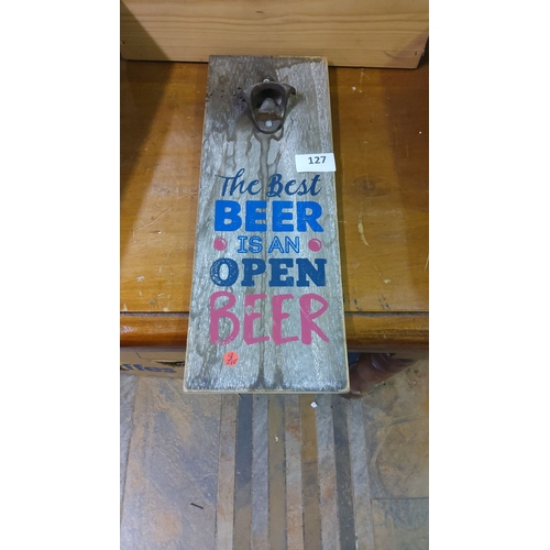 127 - Wooden wall-mounted beer opener features a rustic design with humorous text.