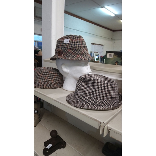 136 - Trio of tweed hats in varying houndstooth and plaid patterns. Includes feather detail.