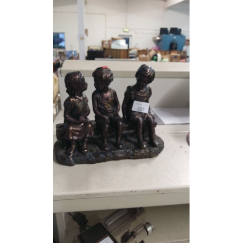 137 - Bronze style sculpture of three children seated on a bench, showcasing detailed whimsical expression... 