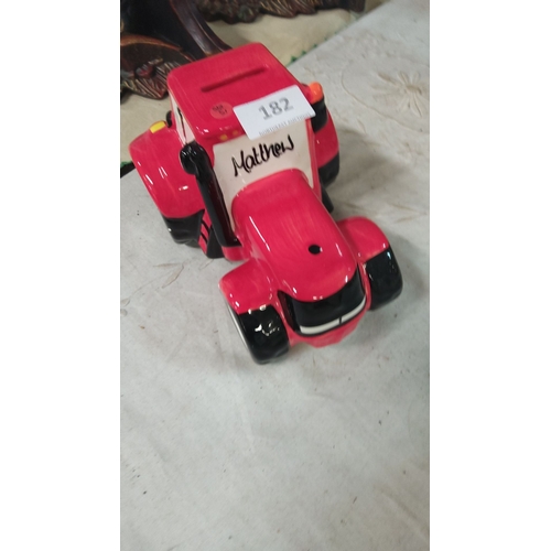 182 - Ceramic red tractor-shaped piggy bank featuring 