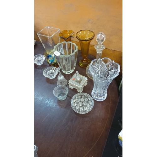 235 - Assorted glassware collection featuring clear and amber vases, bowls, and decorative items.