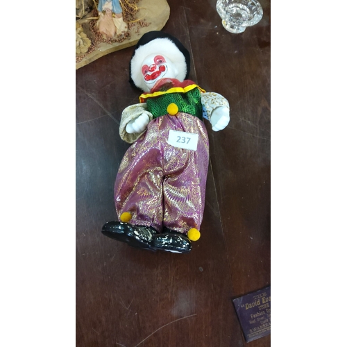 237 - Porcelain musical clown doll with multicolored fabric costume, featuring sequins and lace detailing.... 