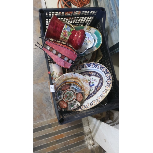 25 - Assorted ceramic and porcelain plates, dishes, and a vibrant red vase, featuring intricate floral an... 