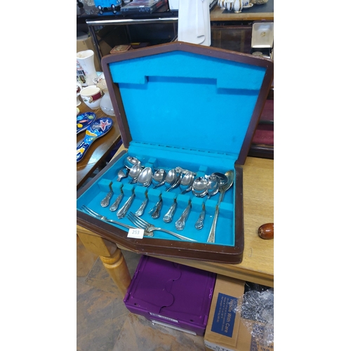 253 - Silver plate part cutlery set in velvet-lined wooden case, featuring ornate handles.