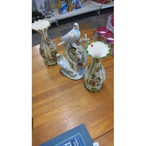 278 - Hand-painted ceramic clock with bird motif, accompanied by two matching capodimonte floral vases, ad... 