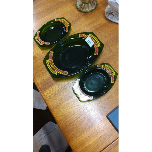 279 - Set of three vintage John Smiths Bitter green glass ashtrays with yellow and red branding.