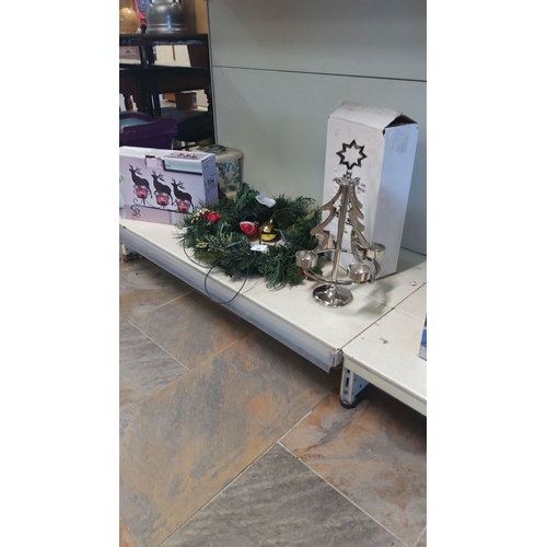 28 - Xmas decor lot featuring a light up wreath, silver-tone candle holder with a star design, and reinde... 