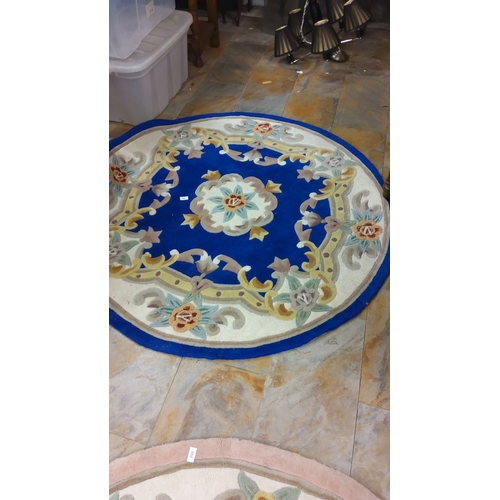 304 - Round wool rug with floral design, featuring vibrant blue, cream, and pastel accents.(6ft diameter)