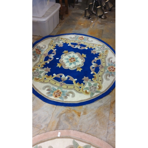 304 - Round wool rug with floral design, featuring vibrant blue, cream, and pastel accents.(6ft diameter)