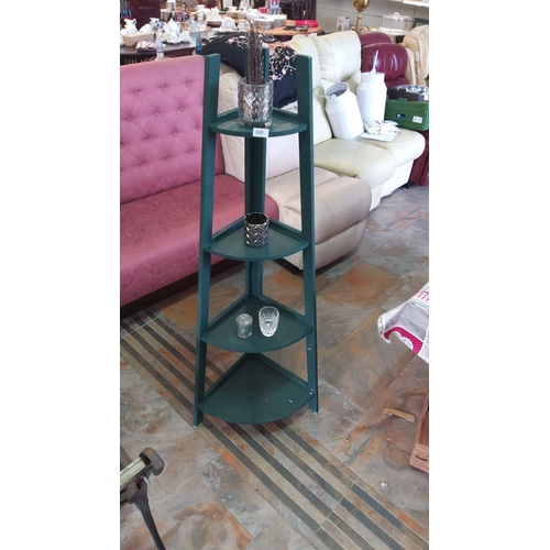 310 - Green corner shelving unit with four tiers.