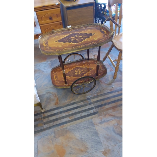 322 - Victorian-style inlaid wooden tea trolley with brass details features intricate floral marquetry and... 