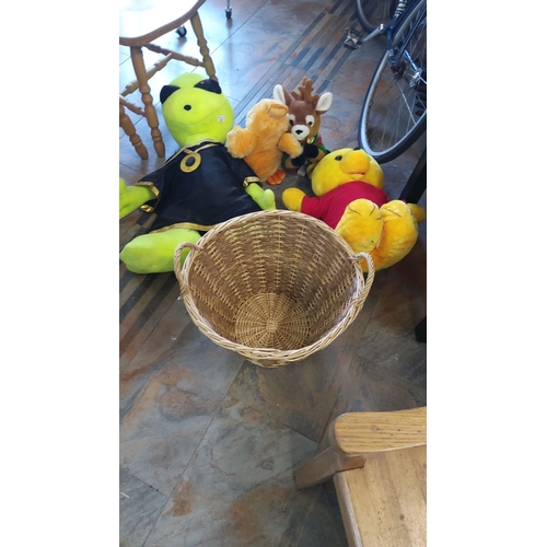 327 - Mixed lot of plush toys including a green alien, yellow bear, and reindeer, paired with a wicker bas... 