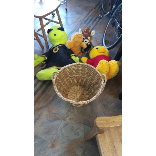 327 - Mixed lot of plush toys including a green alien, yellow bear, and reindeer, paired with a wicker bas... 