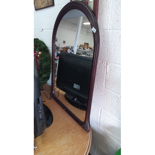 346 - Arched wall mirror with dark wooden frame.