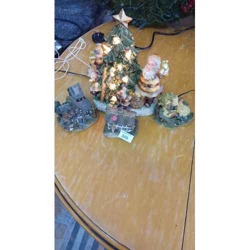 349 - Ceramic scene featuring a lighted Christmas tree, Santa, and three village houses.