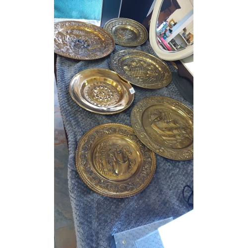 352 - Set of six embossed brass wall plates with maritime and floral motifs.