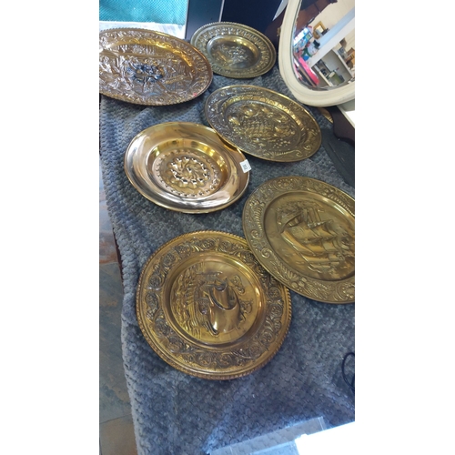 352 - Set of six embossed brass wall plates with maritime and floral motifs.