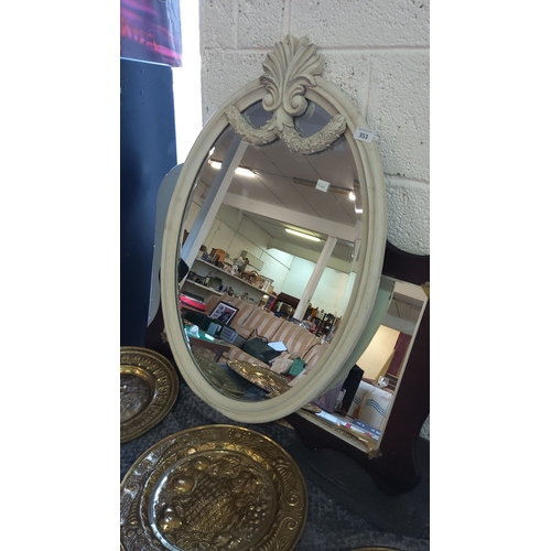 353 - Oval mirror with ornate Victorian-style wooden frame, featuring carved decorative elements at the to... 