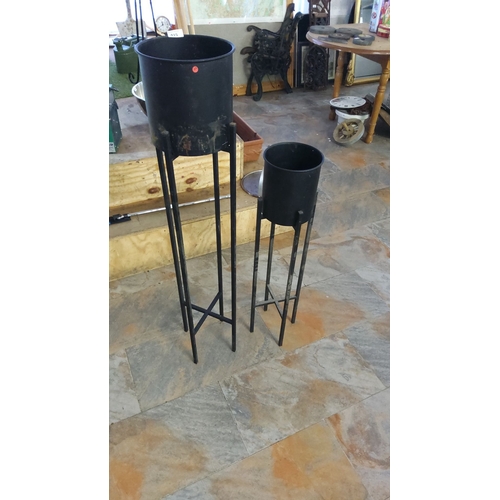 415 - Pair of modern black metal plant stands, tall and short designs, featuring minimalist cylindrical po... 