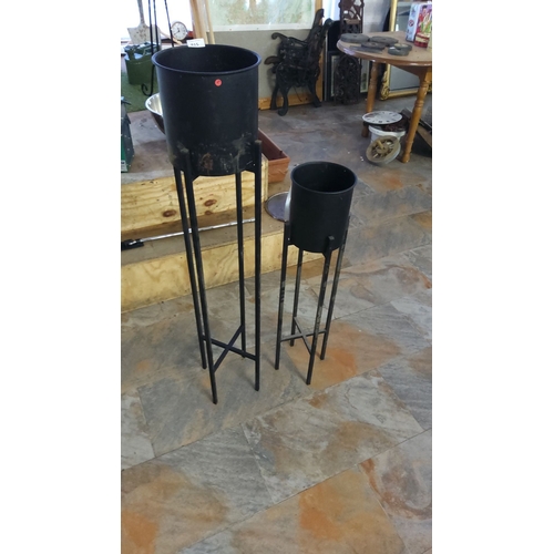 415 - Pair of modern black metal plant stands, tall and short designs, featuring minimalist cylindrical po... 