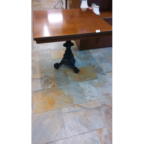 446 - Square wooden table with ornate black cast iron base, featuring intricate scroll and floral design.