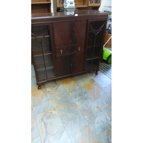 448 - Mahogany book display cabinet with glass doors, central drawers, and brass handles. From the mid 20t... 