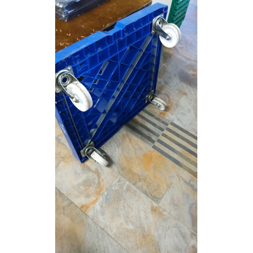 483 - Heavy-duty blue plastic dolly with four swivel casters for easy transport. Sturdy construction.