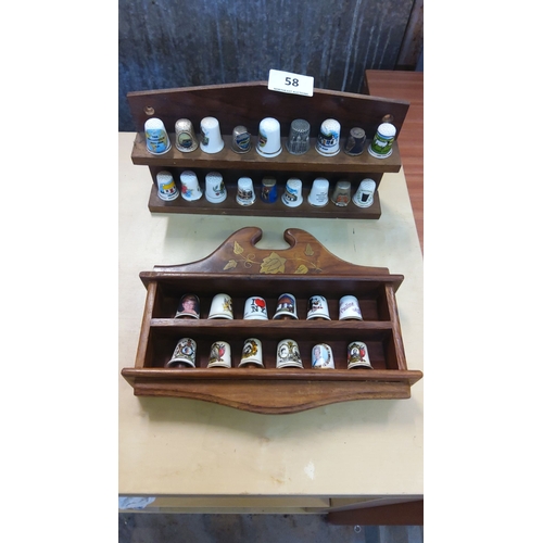 58 - Collection of 30 decorative souvenir thimbles displayed on two wooden racks, featuring various desig... 