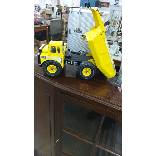 72 - Vintage yellow metal toy dump truck, featuring realistic detailing and movable parts.