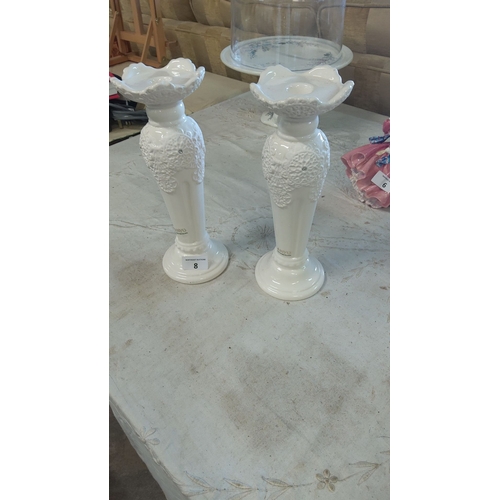 8 - Pair of white porcelain candleholders with embossed floral motifs, labeled 