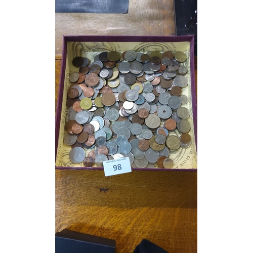 98 - Assorted international coins, mixed denominations and metals, presented in a decorative box.