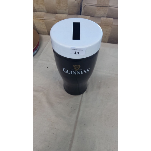 10 - Guinness collectible novelty money box, shaped as a pint glass, featuring iconic logo and design.