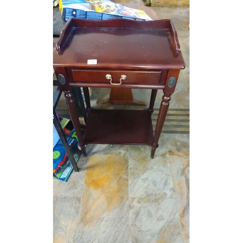 27 - Mahogany side table with a single drawer and lower shelf. Features brass handle and elegant turned l... 