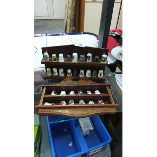 58 - Collection of decorative thimbles with wooden display case, featuring various designs and materials.