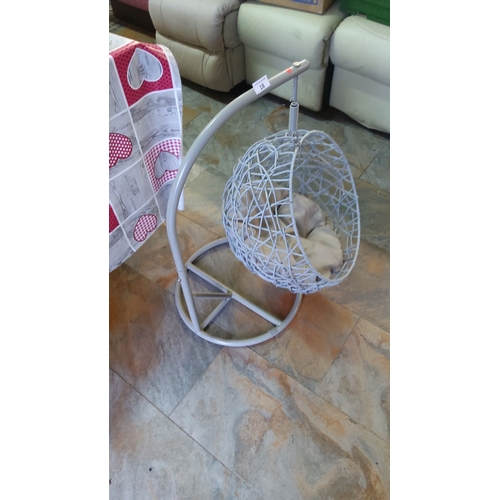 18 - Woven rattan-style hanging chair for pets with a beige cushion, supported by a sturdy metal frame.