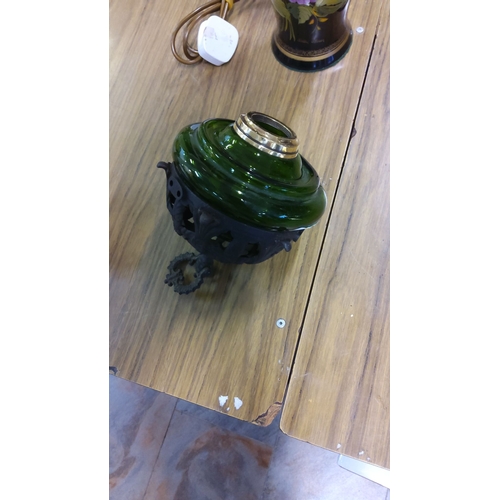 37 - Green glass oil lamp with ornate cast iron base.