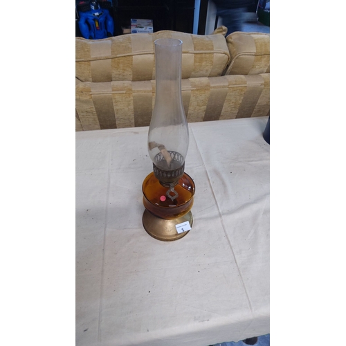 5 - Antique amber glass oil lamp with brass base, featuring a tall glass chimney.