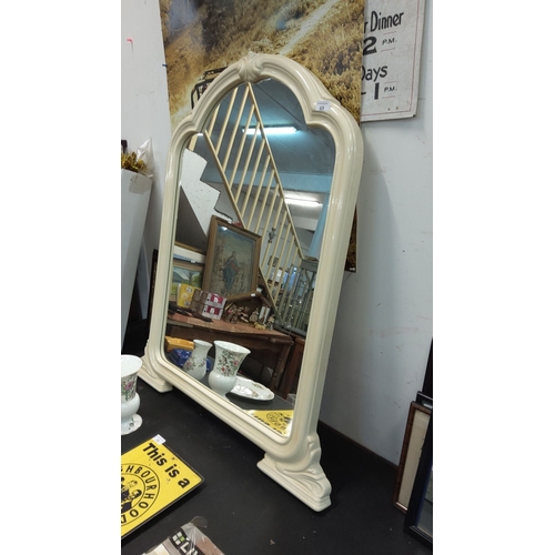 69 - Vintage-style cream-colored mirror with an arched top and carved detailing.