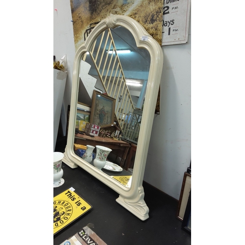 69 - Vintage-style cream-colored mirror with an arched top and carved detailing.