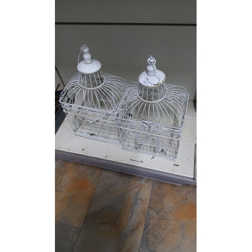 156 - Pair of decorative vintage-style metal birdcages, with a white painted finish, detailed with floral ... 