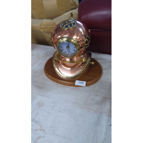 186 - Copper and brass diving helmet clock on wooden base, nautical-themed, modern design.