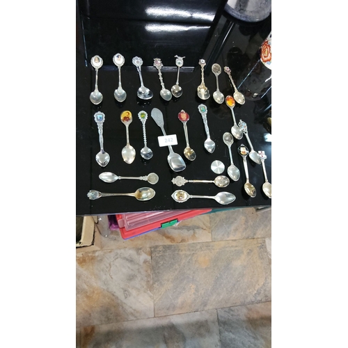 242 - Diverse collection of vintage souvenir spoons featuring varied emblems.