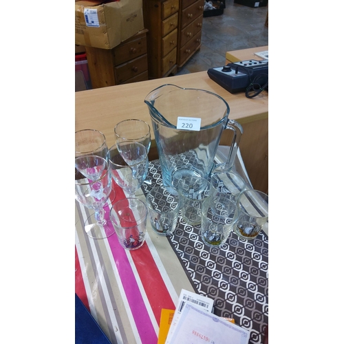 220 - Glassware set includes a large pitcher, ship-motif tumblers, and wine glasses.