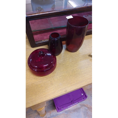 254 - Richly hued ruby glass trio includes cylindrical vase, rounded bowl, and oil lamp base