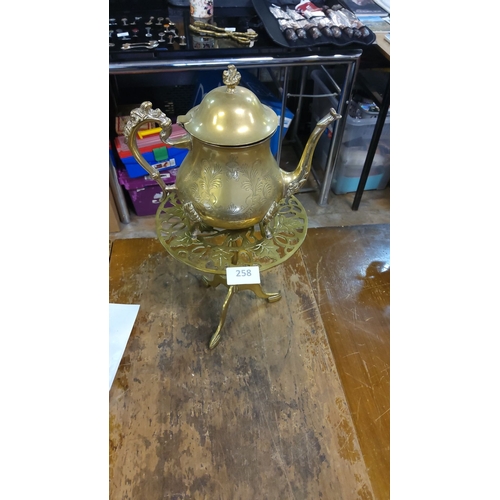 258 - Victorian brass coffee pot with ornate design and elegant trivet stand.