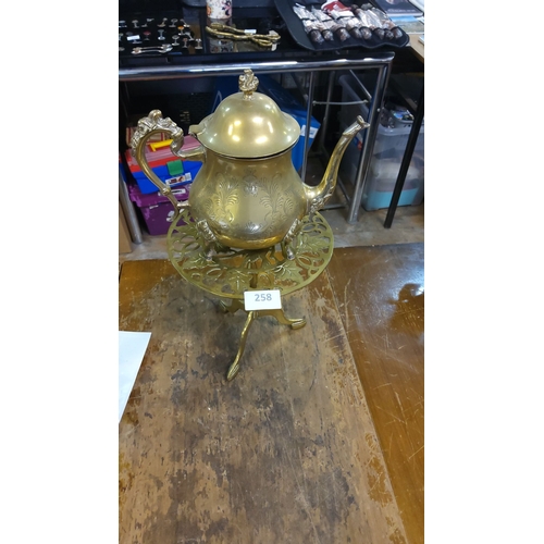 258 - Victorian brass coffee pot with ornate design and elegant trivet stand.